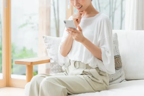 スマートフォンを持つ女性の画像